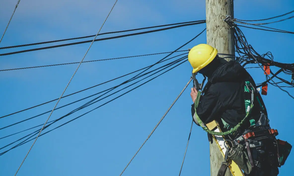 Telecom worker working on a telephone poll of wires
